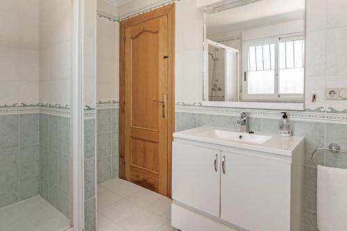a bathroom with a sink and a shower and a mirror at Villa Dos Perlas in Alicante