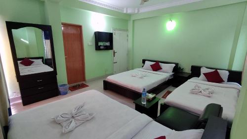 a hotel room with two beds and a mirror at Grand Selim Resort & Tour – GSRT in Sreemangal