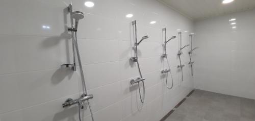 a white bathroom with a row of shower stalls at Umfors Camping in Umasjö