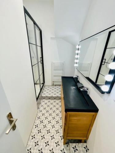 une salle de bain avec un lavabo noir et un miroir dans l'établissement Grand 2 pièces au coeur du centre historique, à Bordeaux