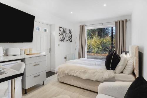 a white bedroom with a bed and a window at Little Laxford in Fazeley