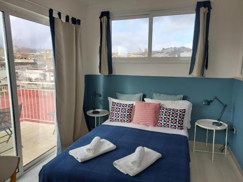 - une chambre dotée d'un lit bleu avec des oreillers et des fenêtres dans l'établissement View of Naples from terrace- 6, à Naples