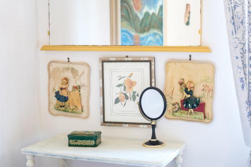 a mirror on a table with pictures on the wall at Casa Vacanza Gungui in Capo Comino