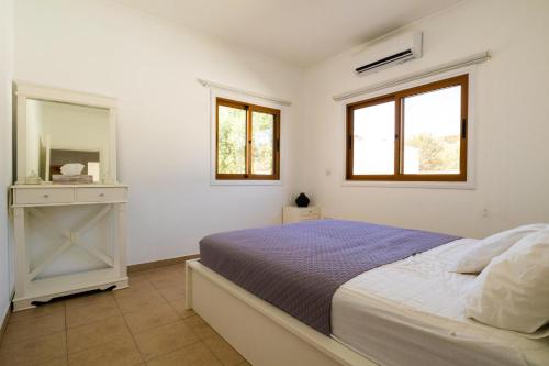 Habitación blanca con cama y espejo en Captivating 2-Bed House, en Alaminos