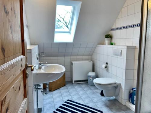 ティンメンドルフにあるFerienhäuser Liethmann Haus 4 W2のバスルーム(洗面台、トイレ付)、窓が備わります。