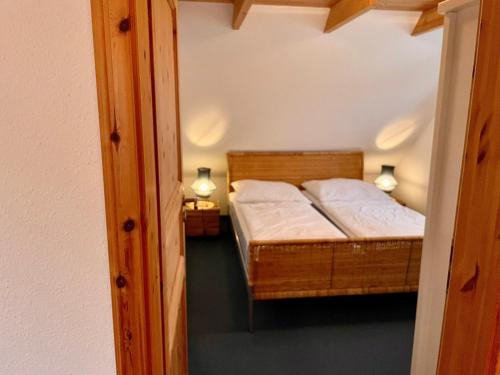 małą sypialnię z łóżkiem i 2 lampami w obiekcie Ferienhäuser Liethmann Haus 4 W2 w mieście Timmendorfer Strand