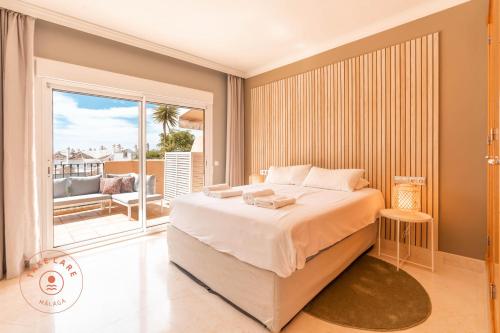a bedroom with a large bed and a balcony at Stylish Apartment Aloha Hill Club Marbella - TCM in Marbella