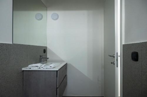 ein weißes Badezimmer mit einem Waschbecken und einem Spiegel in der Unterkunft Strategic Apartment with Terrace - Nola in Nola