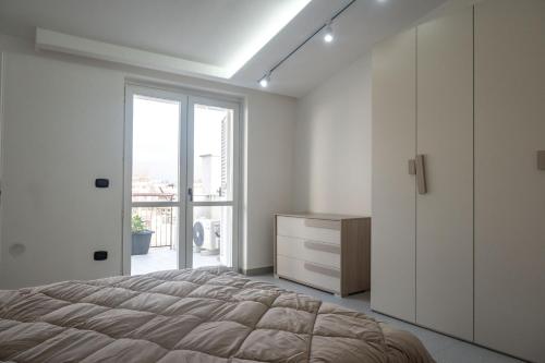 ein Schlafzimmer mit einem Bett, einer Kommode und einem Fenster in der Unterkunft Strategic Apartment with Terrace - Nola in Nola