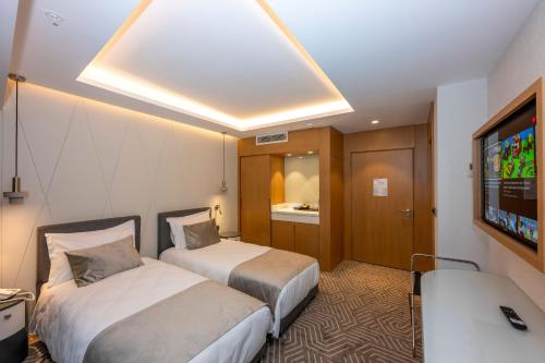 a hotel room with two beds and a flat screen tv at Baver Hotel in Istanbul