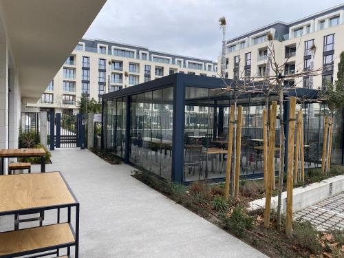 a glass building with tables and benches in front of a building at Studio PAMI in St. St. Constantine and Helena
