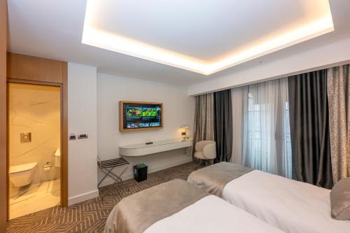 a hotel room with two beds and a bathroom at Baver Hotel in Istanbul