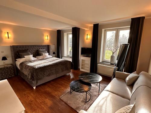 ein Hotelzimmer mit einem Bett und einem Sofa in der Unterkunft Gut Dyckhof in Meerbusch
