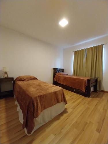 sypialnia z 2 łóżkami i drewnianą podłogą w obiekcie Moras Morada w mieście Almafuerte