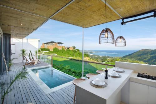 a kitchen with a view of the ocean from a house at Telescope Villas Lombok in Kuta Lombok
