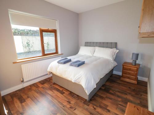 a bedroom with a bed with two towels on it at The Garden Cottage in Crossmaglen