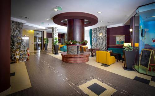 a lobby of a hotel with a fireplace in the middle at Rhodopi Home Hotel Chepelare - Half board in Chepelare