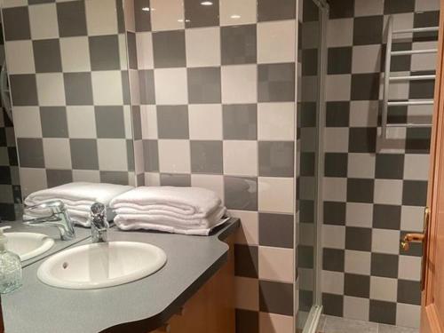 a bathroom with a sink and a checkerboard wall at Guestroom Basse-sur-le-Rupt, 1 pièce, 2 personnes - FR-1-589-626 in Basse-sur-le-Rupt