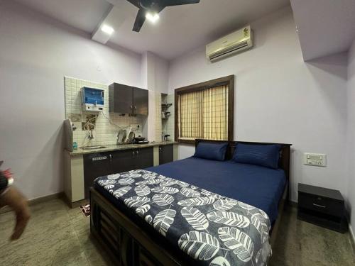 a bedroom with a bed and a kitchen at Amazing AC Studio in E City 3F 302 in Bangalore