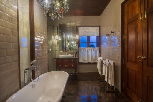 a large bathroom with a tub and a sink at Kandy Dendrobium House in Kandy