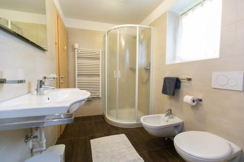 ラ・ヴィッラにあるAppartamenti Genzianaのバスルーム(洗面台、トイレ、シャワー付)