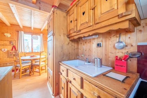 cocina con armarios de madera y comedor con mesa en Chalet L’Embellie - Chalet avec piscine partagée, en Saint-Laurent-en-Grandvaux