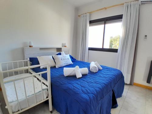 1 dormitorio con 1 cama con sábanas azules y almohadas blancas en Confort urbano - Departamento en Venado Tuerto