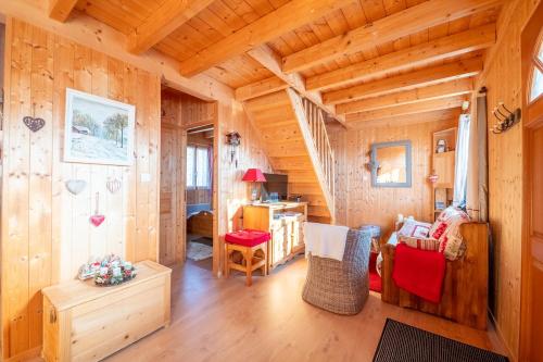 een woonkamer in een blokhut met een houten plafond bij Chalet L’Embellie - Chalet avec piscine partagée in Saint-Laurent-en-Grandvaux