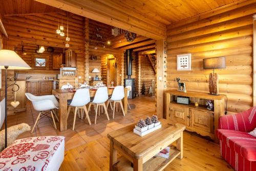 - un salon dans une cabane en rondins avec une table et des chaises dans l'établissement Le Chalet des Ours - Superbe chalet 4 étoiles, aux Angles