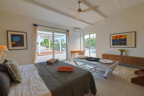 a bedroom with a large bed and a table at Magnifique villa rénovée neuve à Orient Bay in Saint Martin