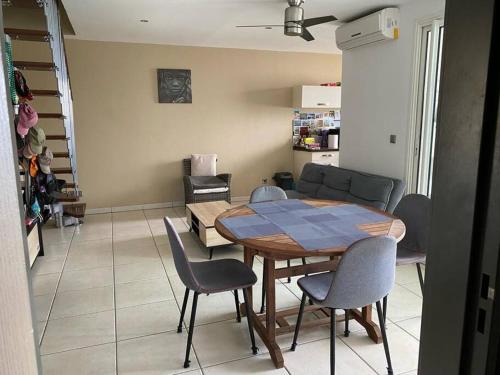 a dining table and chairs in a living room at Appart sympa, vue sur le lagon à Saint-Gilles les bains in Saint-Gilles les Bains