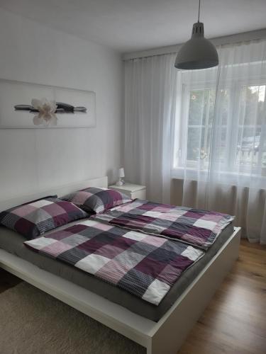 1 dormitorio con 1 cama con manta a cuadros en Gemütliches Wohnen in Frauenkirchen im Burgenland, en Frauenkirchen