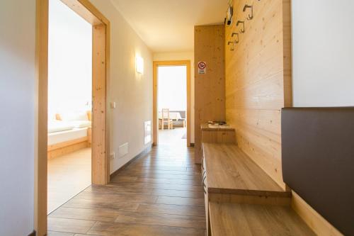 a hallway with wooden floors and a room with a bed at Appartamenti Genziana in La Villa