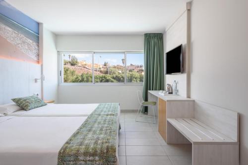 a hotel room with two beds and a window at FERGUS Cactus Garden in Playa Jandia