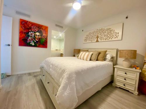 a bedroom with a bed and a painting on the wall at Oceanfront Family Apartment Pool & BBQ in Gold Coast