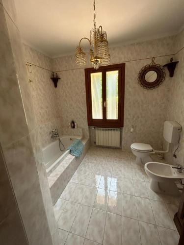 a bathroom with a tub and a toilet and a sink at Villa per gruppi fino a 20 persone, con piscina privata, camino e grande giardino nelle colline marchigiane in Pian di Mulino