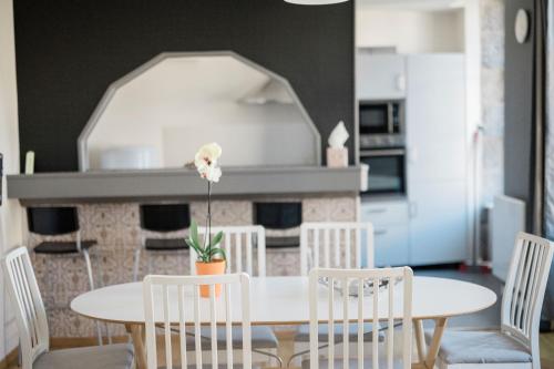 une salle à manger avec une table et des chaises blanches dans l'établissement VOLVIC HOME, à Volvic