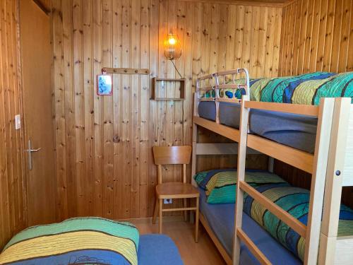 Habitación con 3 literas en una cabaña en Chalet Sunnuterrasse en Rosswald