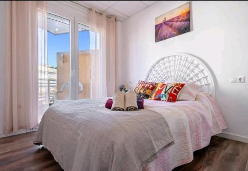una camera da letto con un grande letto con una grande finestra di Apartamento Lauren Salou a Salou