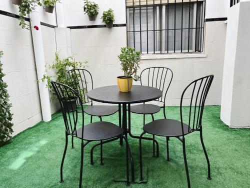 einen Tisch und Stühle auf einer Terrasse mit grünem Gras in der Unterkunft El rincón de Jesús y Loli in Córdoba