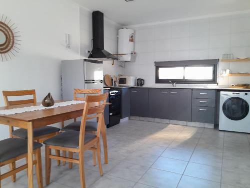 a kitchen with a table and chairs and a kitchen with appliances at Confort urbano - Departamento de 1 dormitorio con cochera in Venado Tuerto