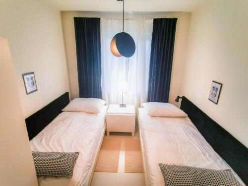 2 Betten in einem kleinen Zimmer mit Fenster in der Unterkunft Apartamenty Bystrzycka 63 in Polanica-Zdrój