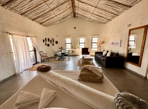 ein großes Wohnzimmer mit einem großen Sofa und einem Wohnzimmer in der Unterkunft Daureb Isib Campsite and B&B in Uis