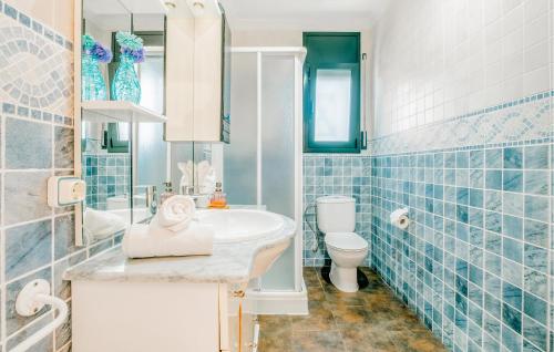 baño de azulejos azules con lavabo y aseo en Awesome Home In Valldemar With Wi-fi, en Gornal