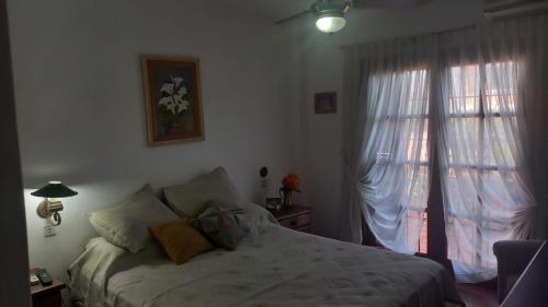 una camera con letto e finestra con tende di CASA AMPLIA Y CONFORTABLE a Córdoba