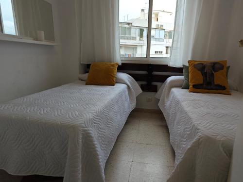 two twin beds in a room with a window at Fuengirola Central in Fuengirola
