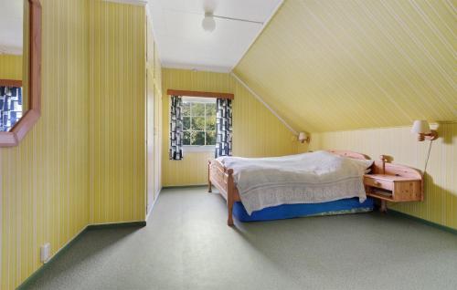 a bedroom with yellow walls and a bed and a window at 5 Bedroom Cozy Home In Strandebarm in Strandebarm