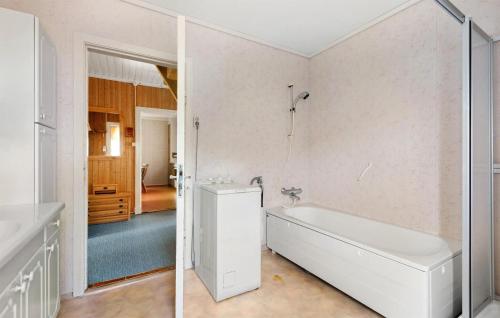 a white bathroom with a tub and a shower at 5 Bedroom Cozy Home In Strandebarm in Strandebarm