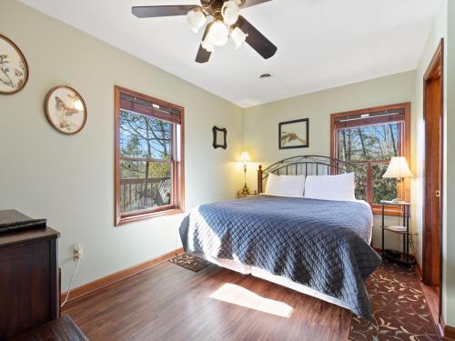 ein Schlafzimmer mit einem Bett und zwei Fenstern in der Unterkunft Annie’s Smoky View, 2 Bedrooms, Hot Tub, Pool Table, Views, Sleeps 6 in Gatlinburg