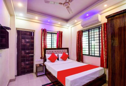 a bedroom with a large bed with red pillows at Goroomgo RS Villa Newtown Kolkata in Pānchuria